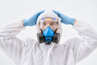 Kapat. Profesyonel dezenfektan, koruyucu tulum giyiyor..
