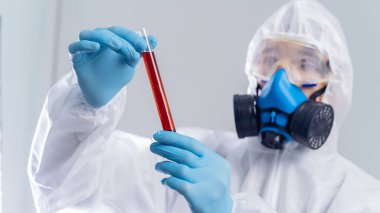 Biyolojik olarak tehlikeli bir maddeye sahip bir şişeyle virüs uzmanı. .