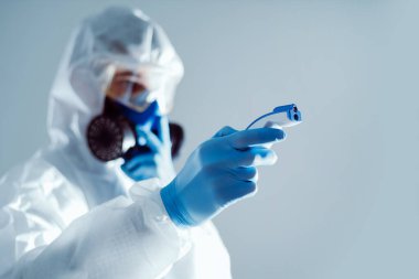 Sıcaklığı elektronik termometreyle ölçen bir doktorun arkaplan resmi .