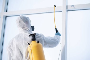 Bir temizlik şirketinin çalışanı mülkü dezenfekte eder. .