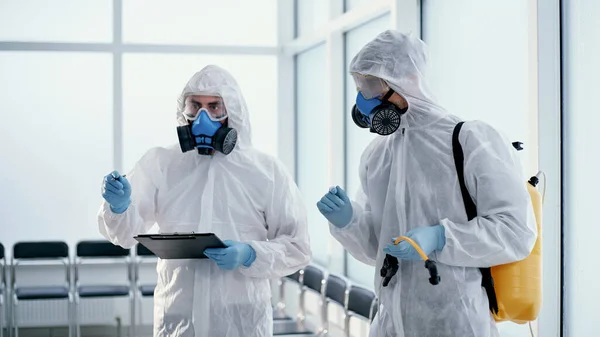 Equipo de desinfectante profesional haciendo un registro del trabajo realizado . — Foto de Stock