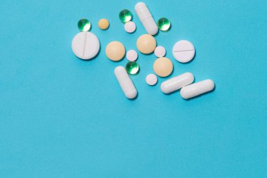 Mavi arka planda tabletler ve diyet takviyeleri .