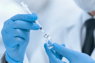 Kapat. Koruyucu eldivenli bilim adamı yeni aşıyı test ediyor. .