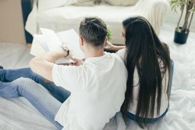 Bir aile albümünde eski fotoğraflara bakan çift..