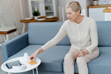 Olgun bir kadın paketten hap alıyor. .