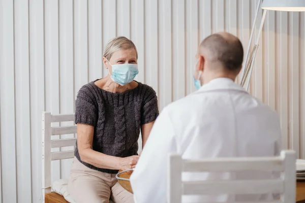 woman asking questions to a doctor during a visit .