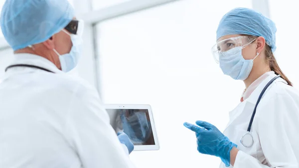 Kvinna läkare tittar på skärmen på en digital tablett. — Stockfoto