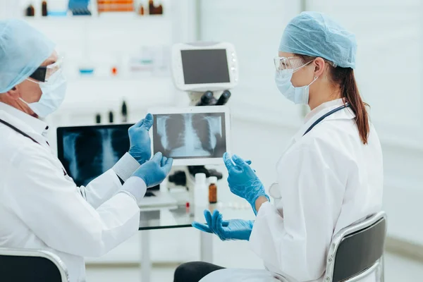 Colegas médicos discutiendo una radiografía en una pantalla de tableta digital. —  Fotos de Stock