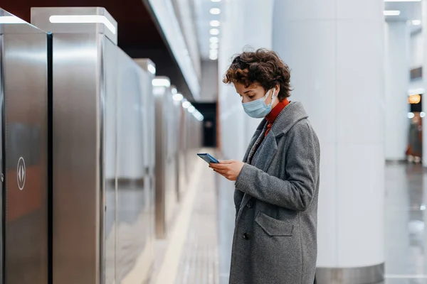 Frau liest auf U-Bahn-Bahnsteig eine Nachricht vor. — Stockfoto