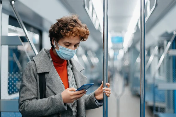 Jovem mulher usando smartphone durante passeio de metrô. — Fotografia de Stock