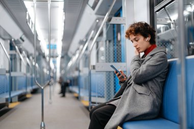 Metroda giderken akıllı telefon kullanan bir kadın. .