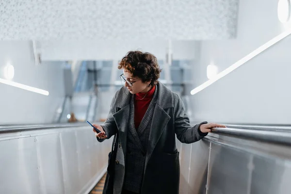 Intelligente Frau erklimmt Rolltreppe in der U-Bahn. — Stockfoto