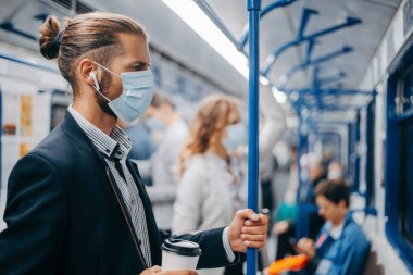 Metro vagonunda duran kahveli genç adam..