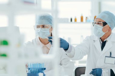 Bilimsel meslektaşlar laboratuvar masasında oturmayı tartışıyor..
