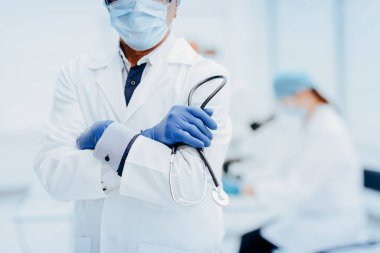 Laboratuvarın arka planında elinde steteskopla doktorluk yapıyor..
