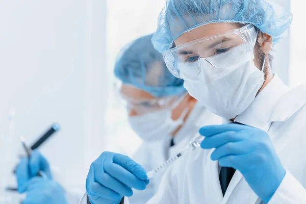 Fecha. grupo de cientistas em vestuário de protecção que trabalham no laboratório. — Fotografia de Stock