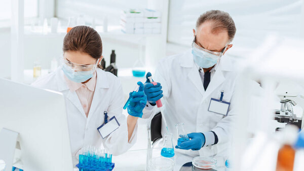 through the glass. scientists work in a medical laboratory .