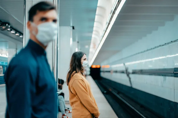 Passageiros em máscaras de proteção em pé na estação de metro — Fotografia de Stock