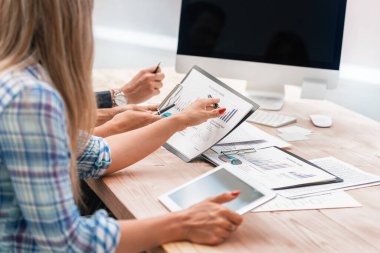 İş adamları mali raporu masaya oturarak tartışıyor.