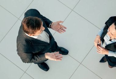 Üst Manzara. İş arkadaşları ofiste dikilirken konuşur..