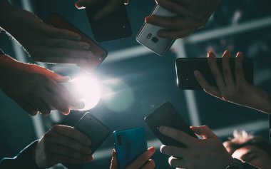Çeşitli akıllı telefonlar genç iş adamlarının elinde. .