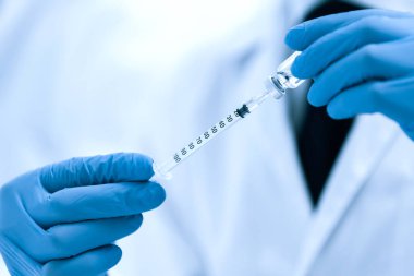 Kapat. Bilim adamı şırıngayı yeni aşıyla dolduruyor. .