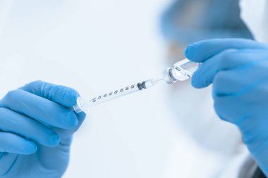 Kapat. Sıhhiyenin elinde yeni bir aşı olan şırınga..