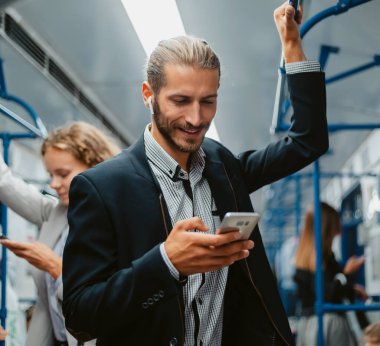 Gülümseyen yolcu akıllı telefonundan mesaj okuyor..