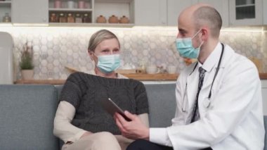 Doktor ev ziyareti sırasında akıllı telefonunu kullanıyor..