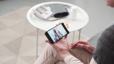 Uzman doktor görüntülü konuşma için olgun bir kadına danışıyor. .