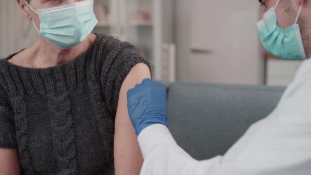 Žena v ochranné masce dostává injekci vakcíny. — Stock video