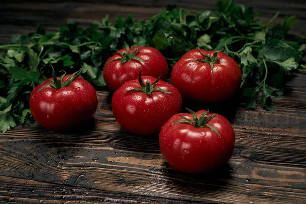 Tomates jugosos maduros en una tabla de madera. — Foto de Stock