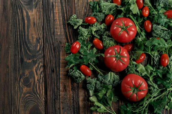 Tomates y pimientos rojos en una tabla de madera. — Foto de Stock