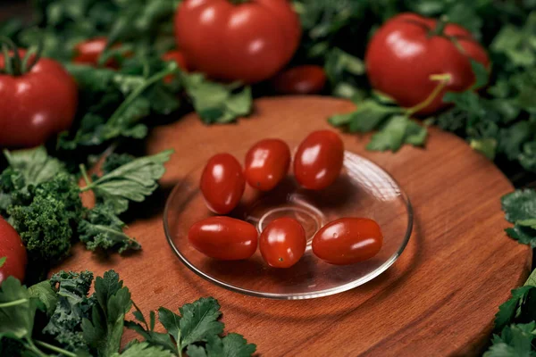 Imagen de un plato de tomates en un tablero de cocina de madera. — Foto de Stock