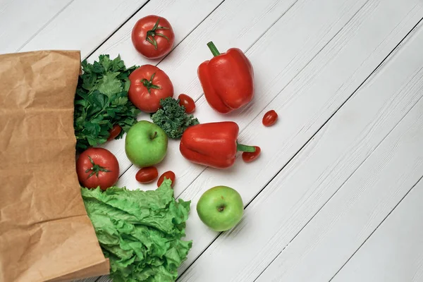Bolsa de verduras frescas sobre un fondo de madera claro . — Foto de Stock