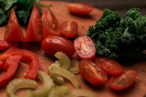 Tahta bir mutfak tahtasında dilimlenmiş turşu ve domates..