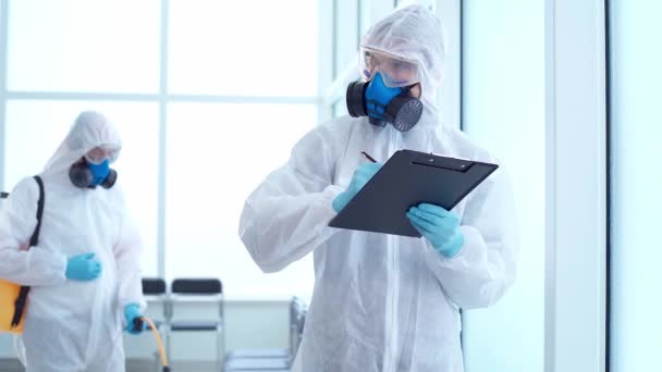 Dipendente del servizio di disinfezione prendendo appunti sul lavoro svolto. — Video Stock