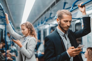 Metro vagonundaki yolcular güvenli bir mesafede duruyorlar. .
