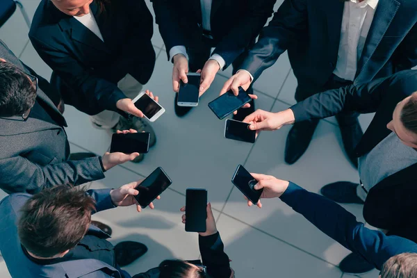 Fecha. jovens empresários com smartphones de pé em um círculo. — Fotografia de Stock