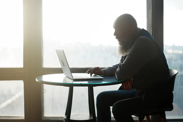 Affärsman med bärbar dator som sitter nära panoramafönster . — Stockfoto