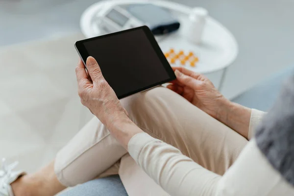 Žena s digitálním tabletem sedící v lékařské ordinaci. — Stock fotografie