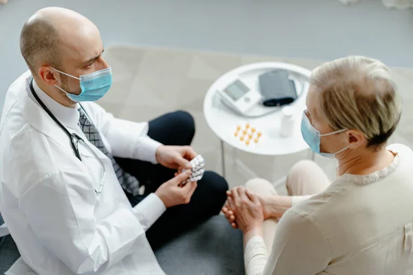 Médico en casa explica al paciente las reglas para tomar medicamentos . —  Fotos de Stock