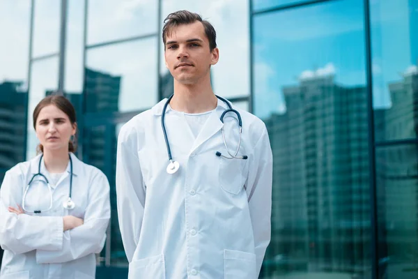 Bir grup ciddi genç doktor hastanenin önünde duruyor.. — Stok fotoğraf