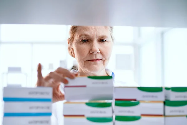 Farmacêutico feminino escolher o produto médico certo. — Fotografia de Stock
