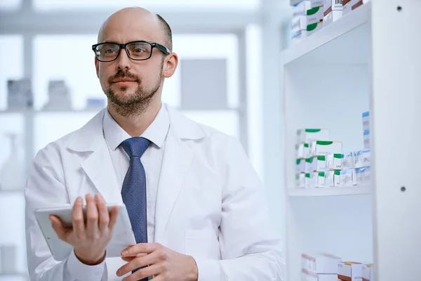 Farmacista con un tablet digitale in piedi nella sua farmacia. — Foto Stock
