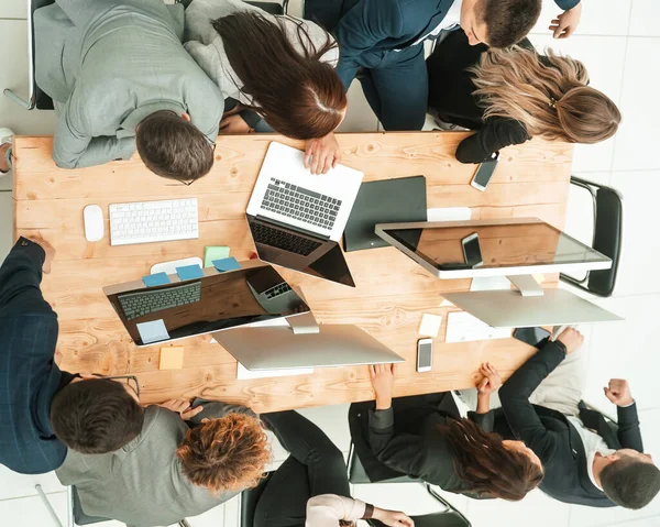 Vista dall'alto. team di lavoro seduto alla scrivania e guardando lo schermo vuoto — Foto Stock