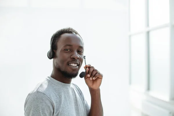 Vista lateral. joven con auriculares hablando en el micrófono — Foto de Stock