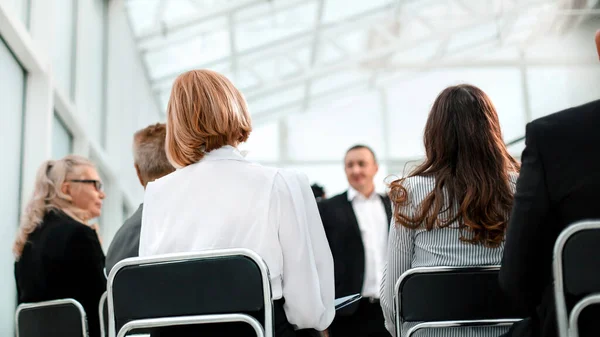 Vista trasera. participantes del seminario de negocios sentados en la sala de conferencias — Foto de Stock