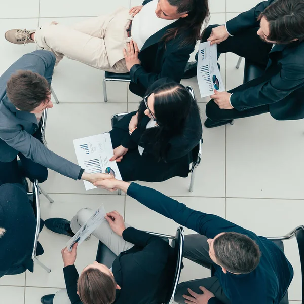 Jovens empregados que se apoiam mutuamente com um aperto de mão . — Fotografia de Stock