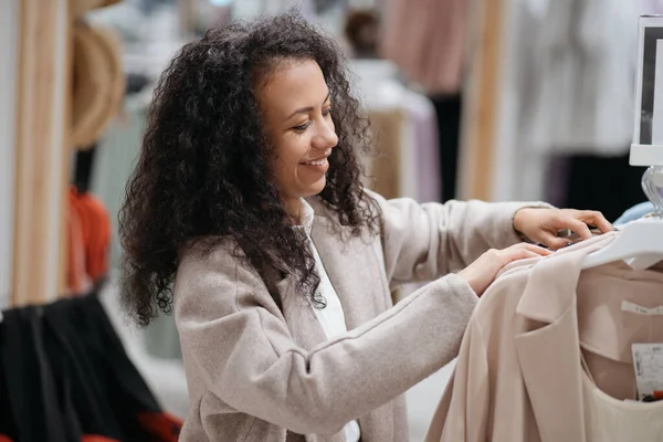 Junge Frau wählt Kleidung im Laden. — Stockfoto